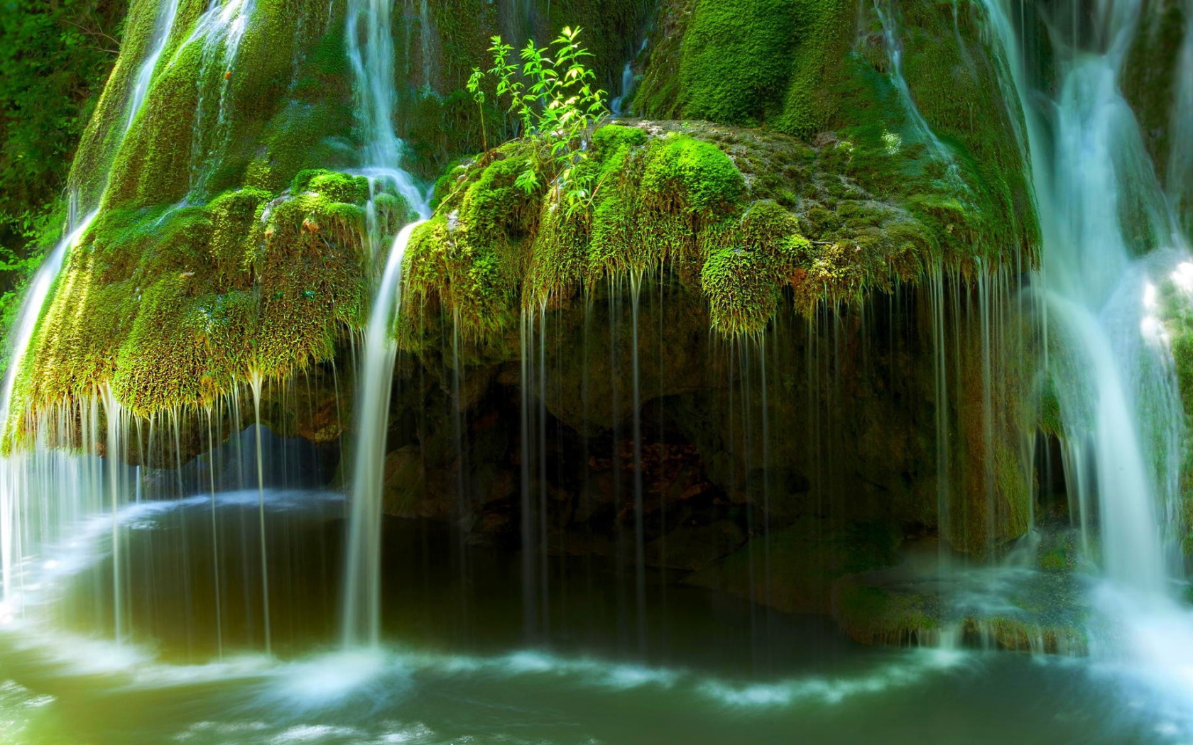 Вода стекает по покрытым мхом скалам