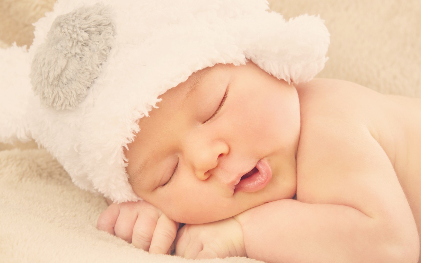 Спящий ребенок в белой шапке