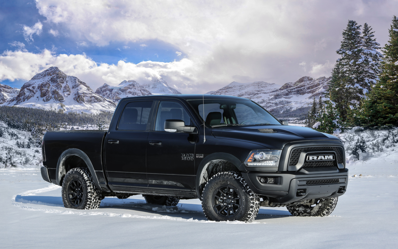Автомобиль пикап Ram 1500 Rebel Black, 2017 года на фоне заснеженных гор 