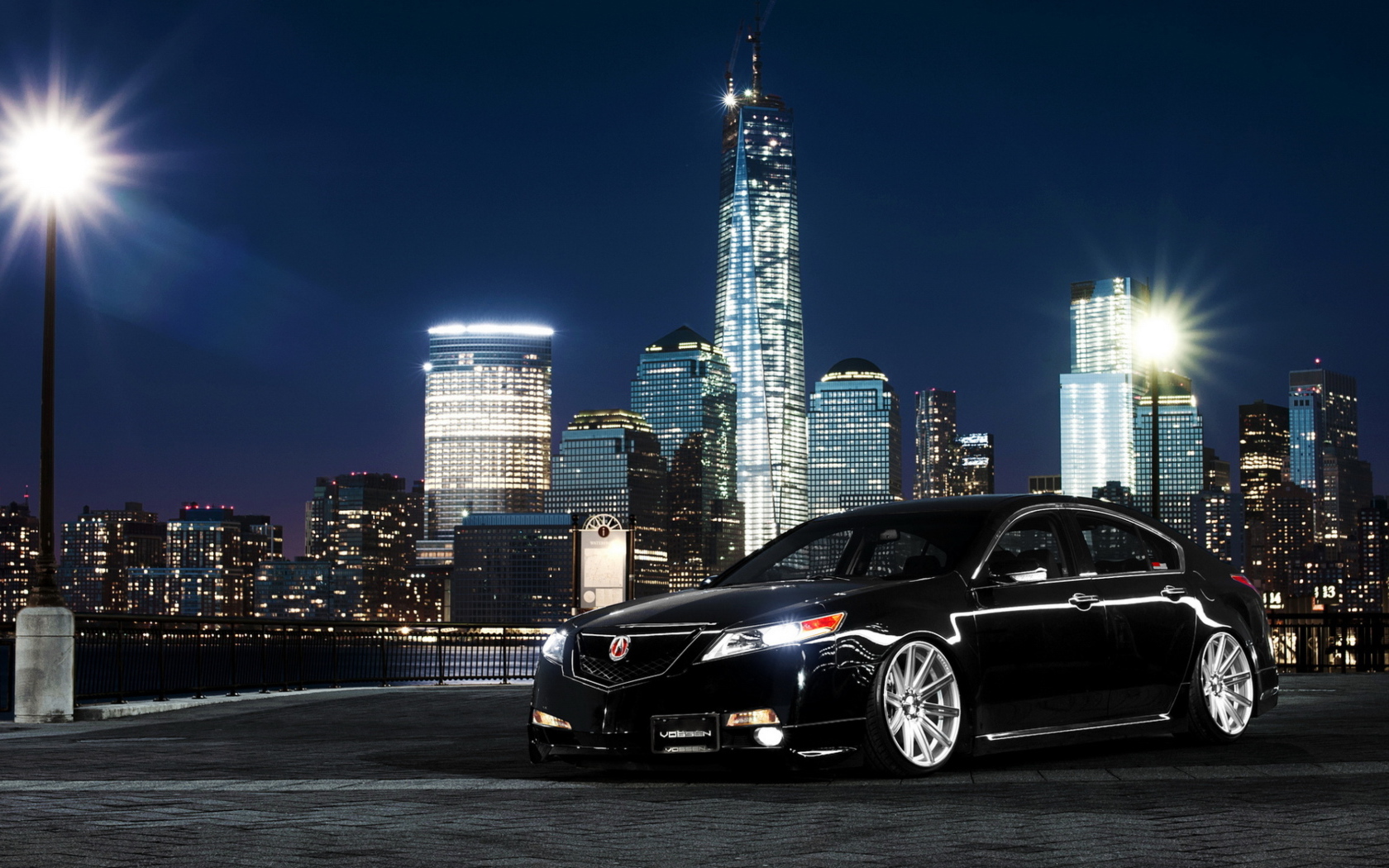 Черный автомобиль Acura TL на фоне ночных небоскребов 