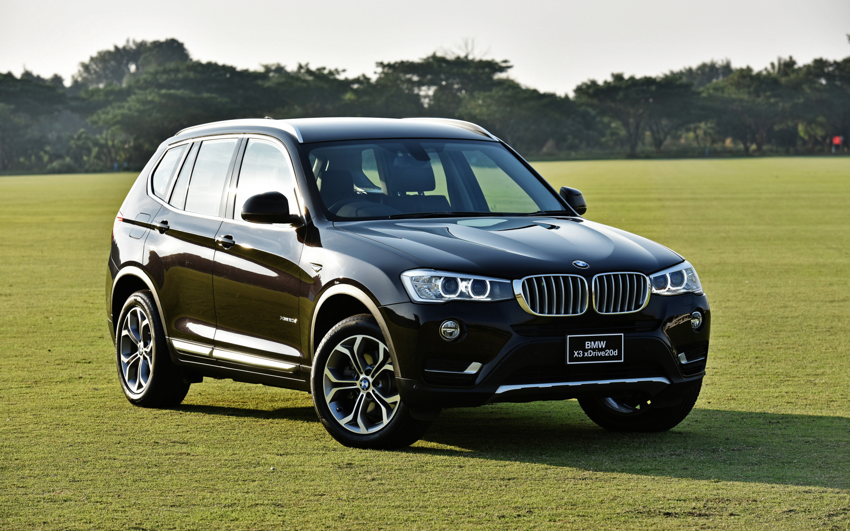 Черный автомобиль  BMW X3 на поле для гольфа 