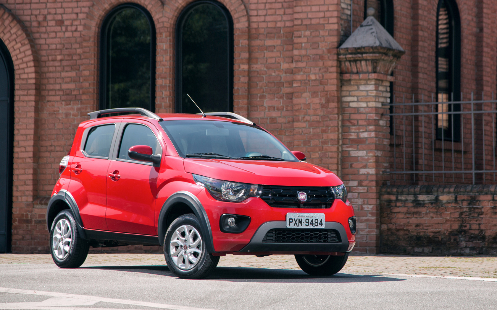 Красный автомобиль Fiat Mobi Way у здания