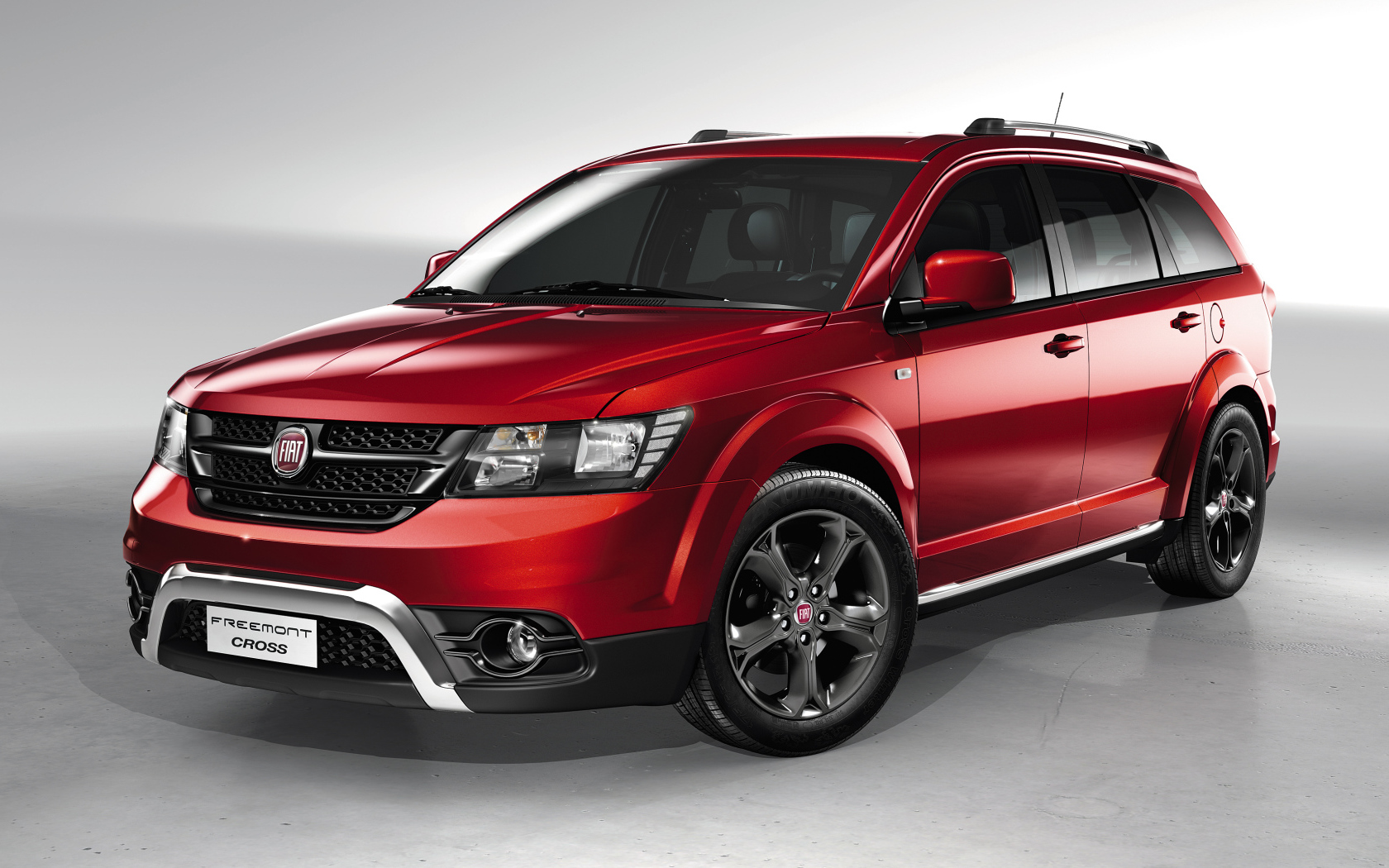 Красный автомобиль внедорожник Fiat Freemont Cross на сером фоне