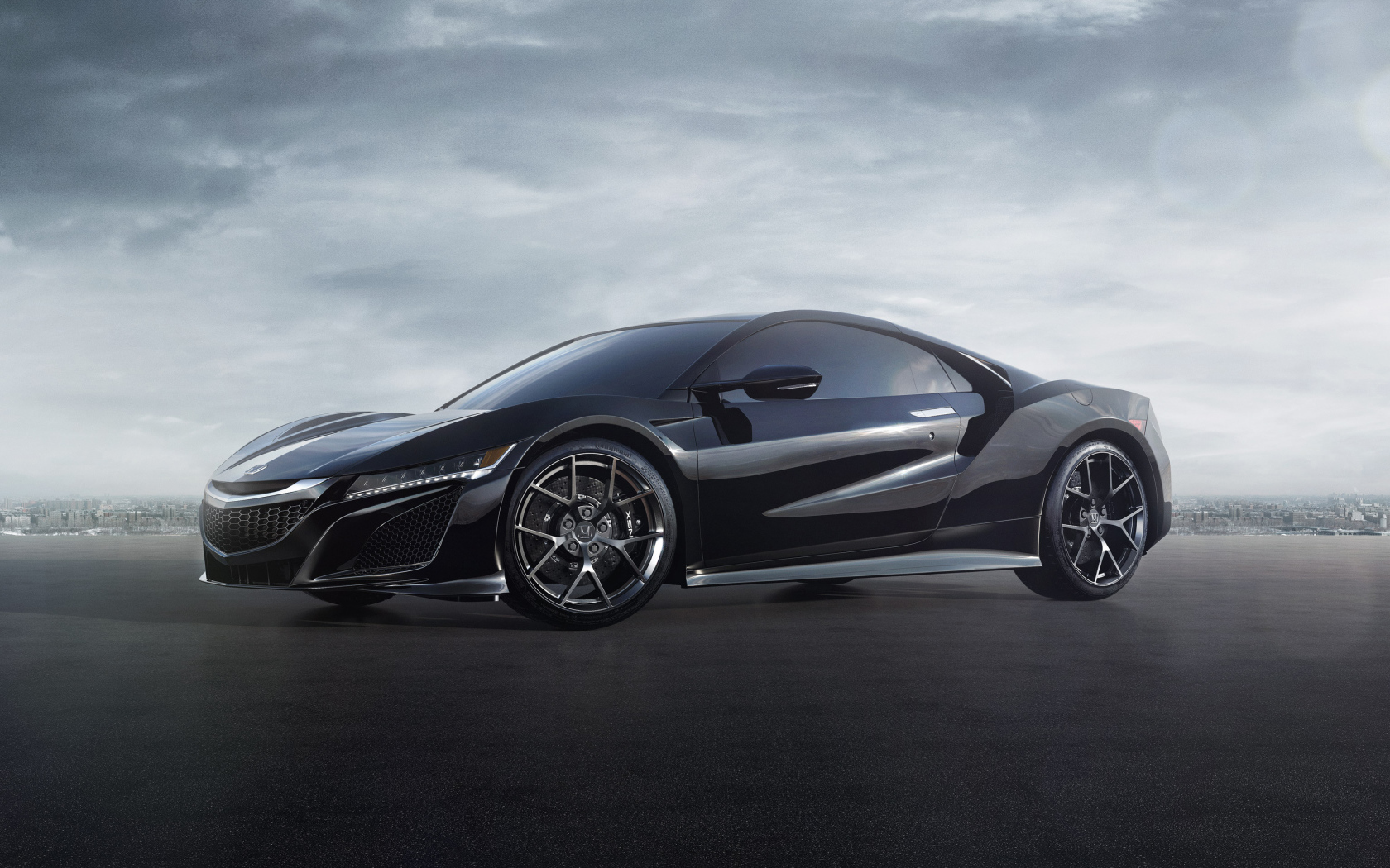 Черный спортивный автомобиль Honda NSX под пасмурным небом