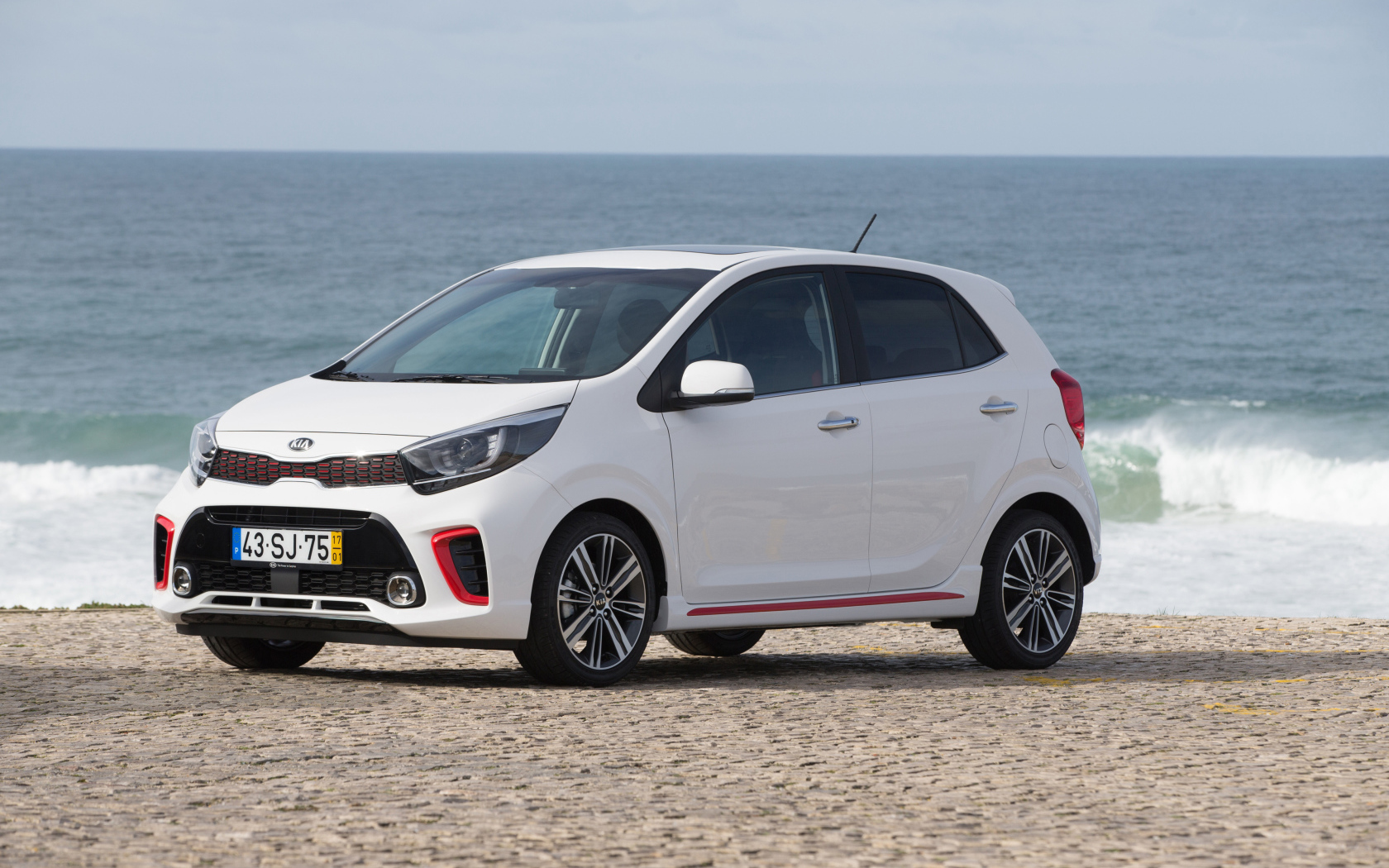 Белый автомобиль KIA Picanto GT Line, 2017 на фоне океана 