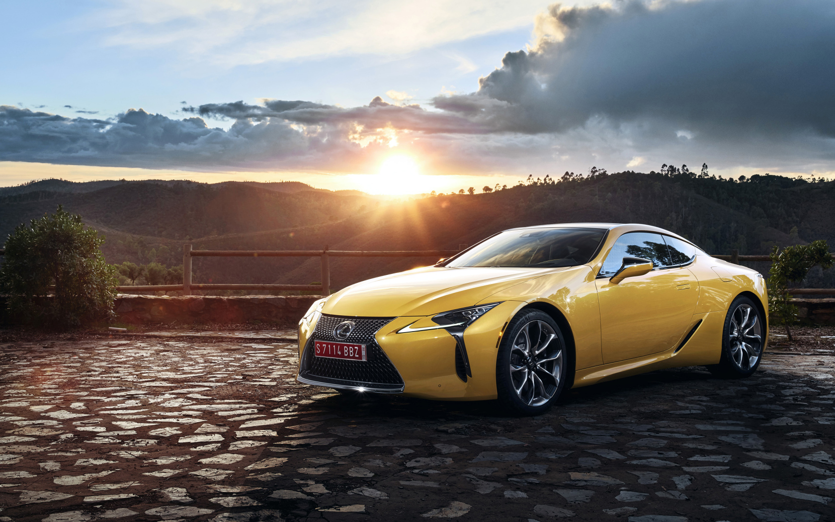 Желтый автомобиль Lexus LC 500  на фоне заката 