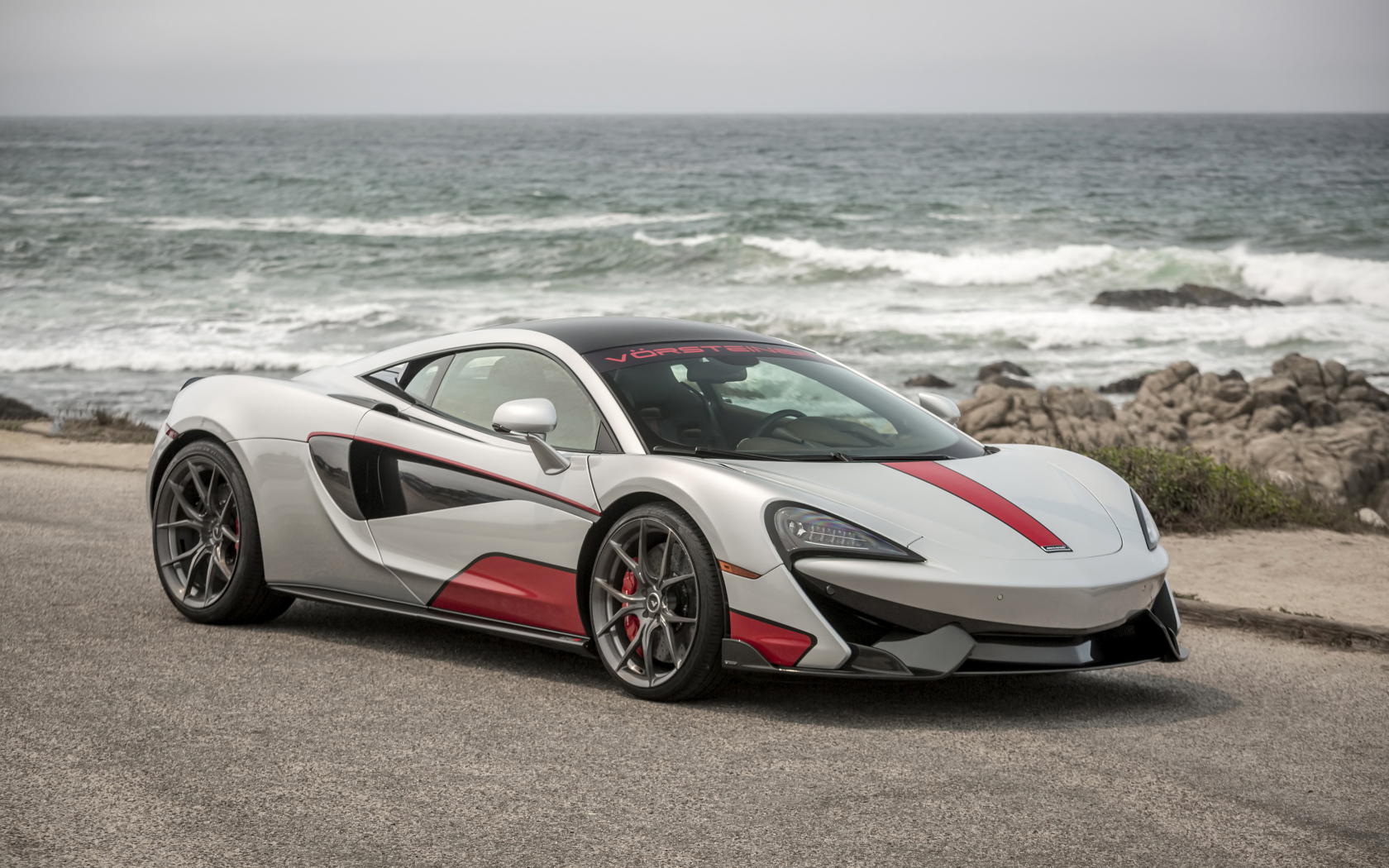 Спортивный автомобиль McLaren 570S на фоне океана