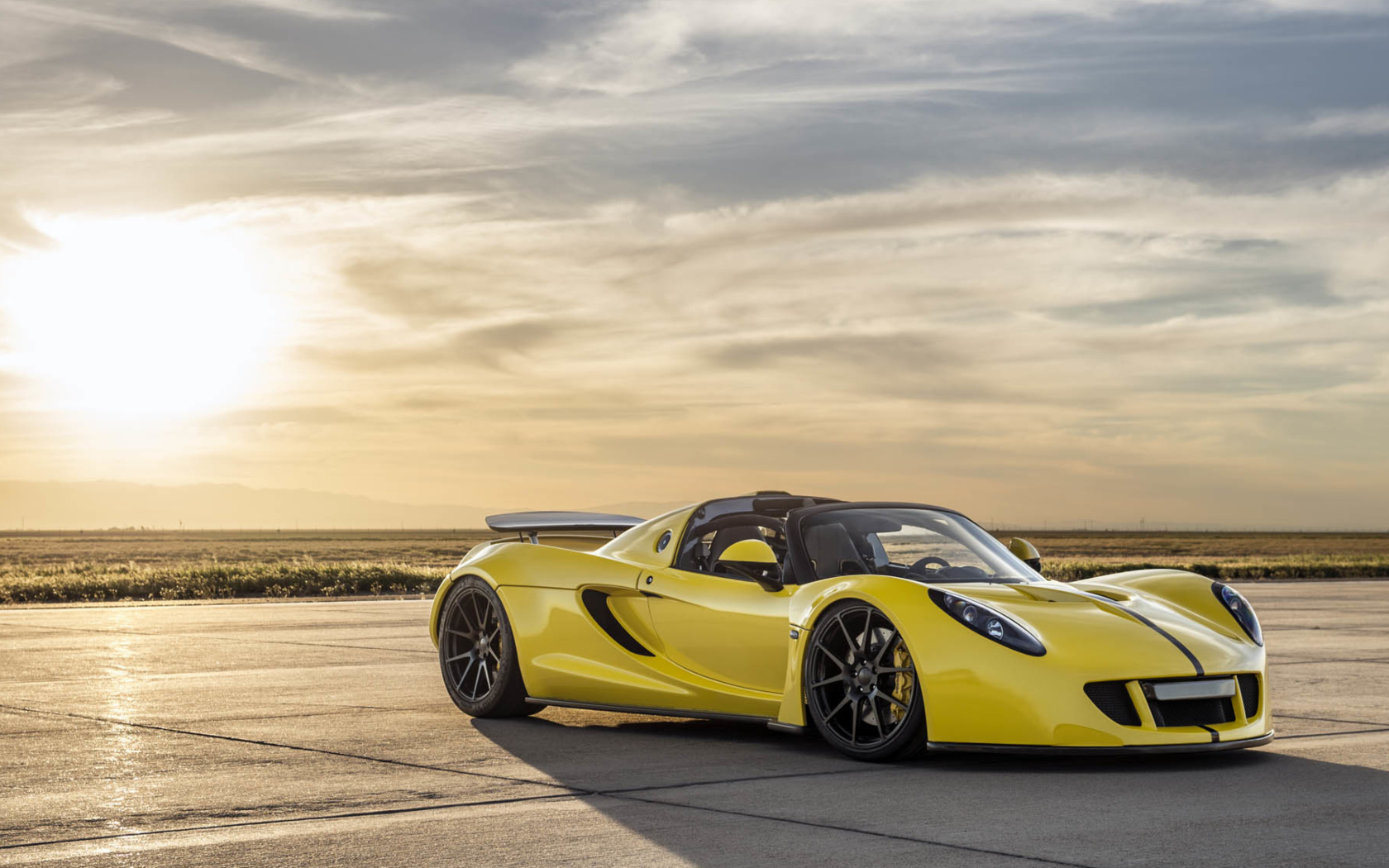 Автомобиль Hennessey Venom GT на фоне солнца в небе