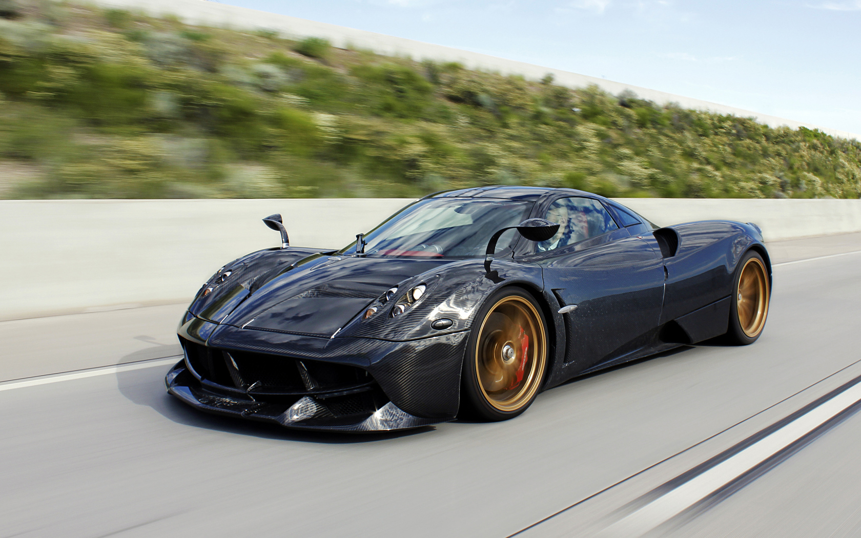Черный спортивный автомобиль Pagani Huayra на трассе 
