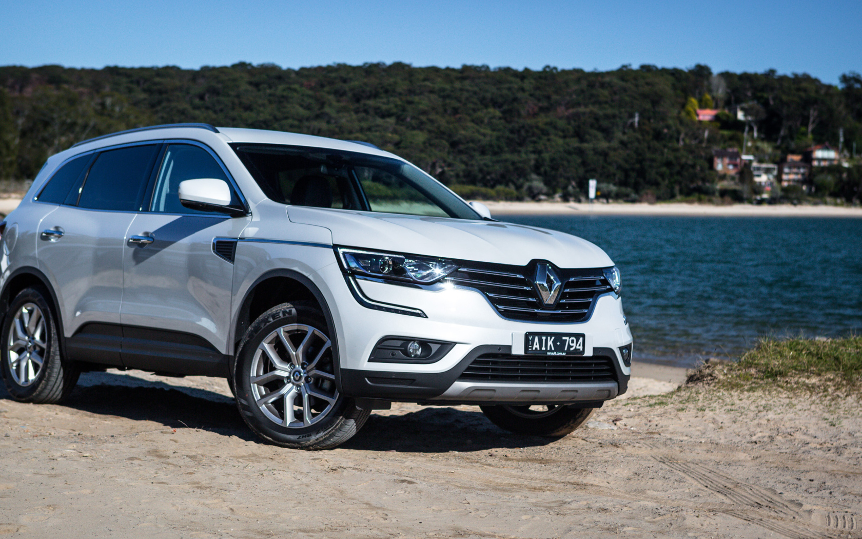 Белый автомобиль Renault Koleos у водоема