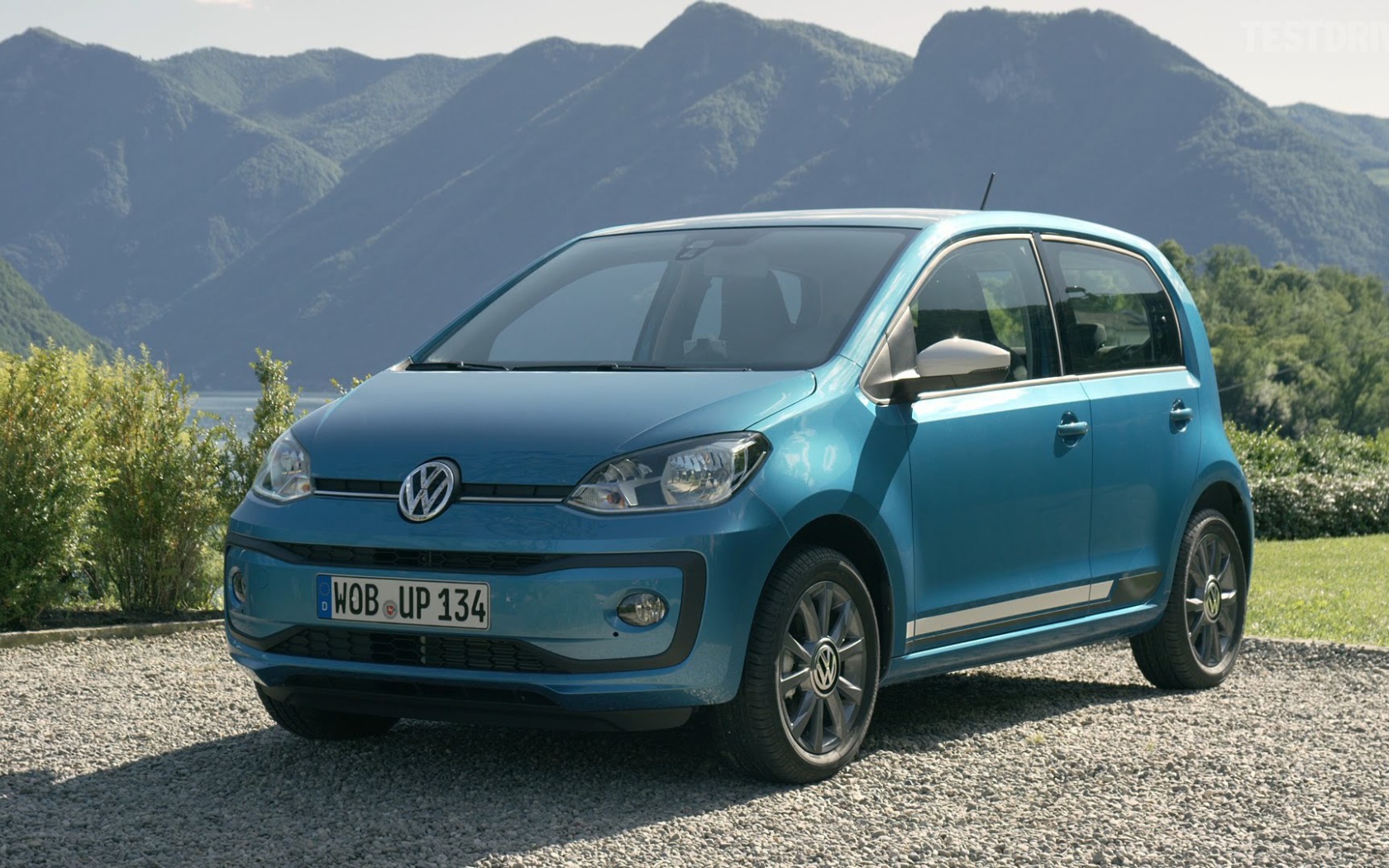 Синий Volkswagen Up 2017 года на фоне гор 