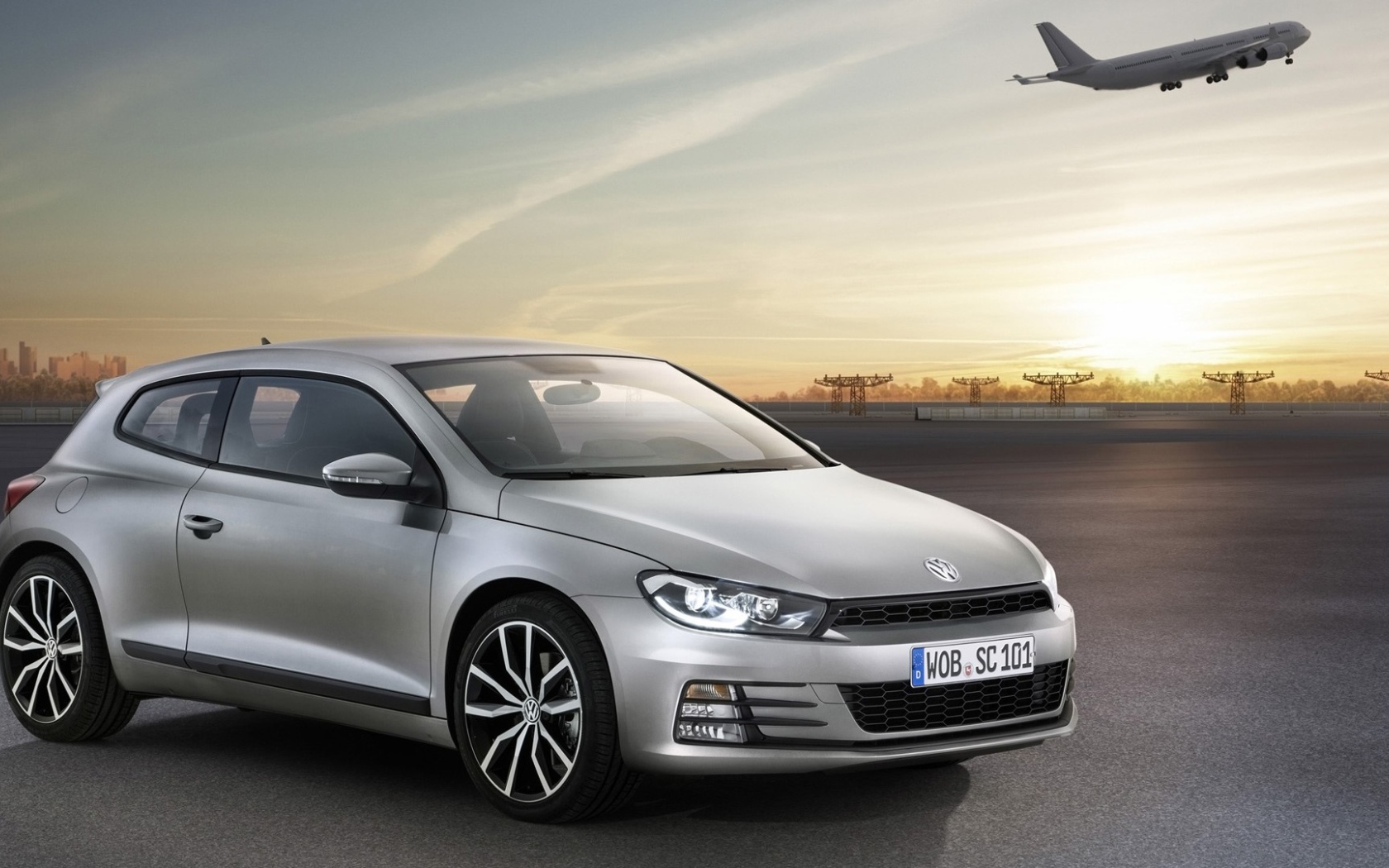 Серебристый Volkswagen Scirocco 2017 года на фоне взлетной полосы 