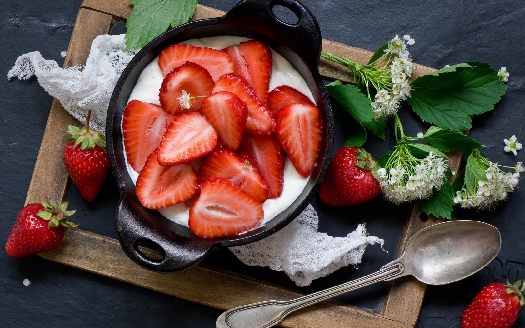 Свежая клубника с йогуртом на завтрак на столе с белым цветком