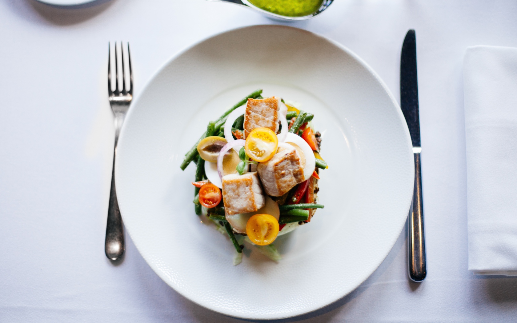 Овощной салат на белой тарелке со столовыми приборами