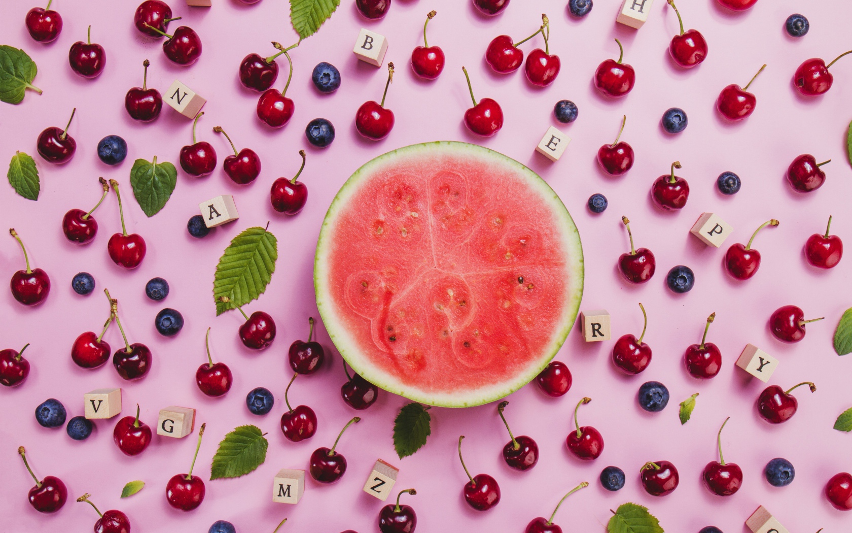 Половина арбуза с ягодами вишни и черники на столе