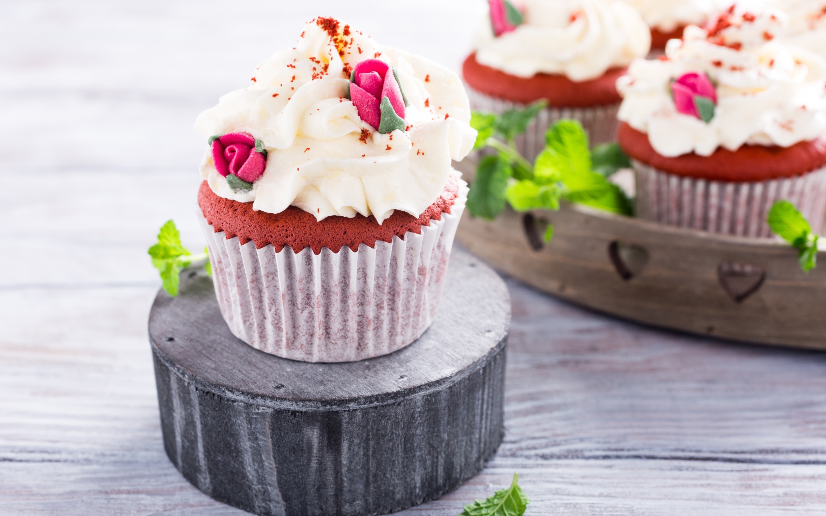 Шоколадный капкейк с кремом и розочками на столе