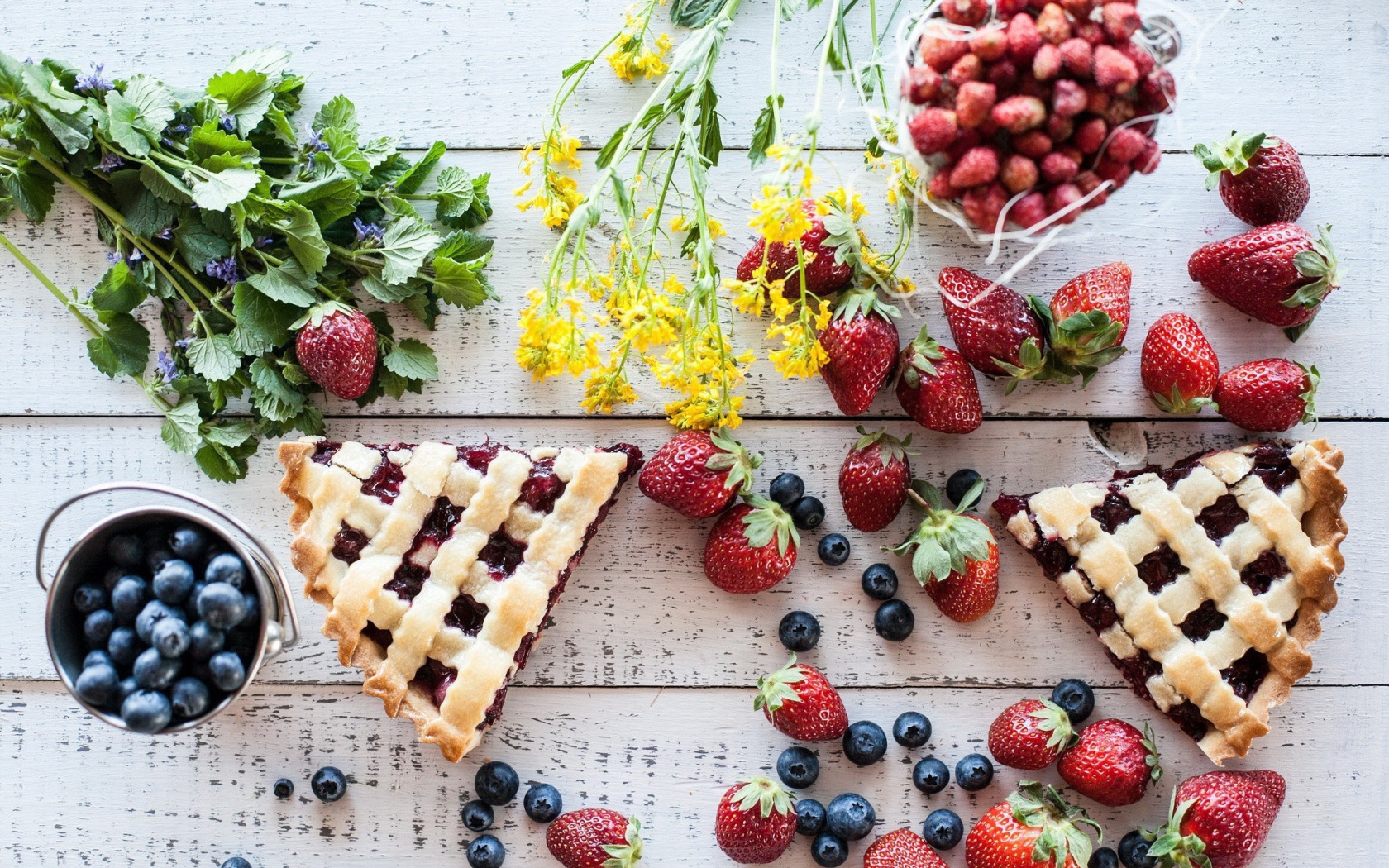 Кусочки пирога на столе с ягодами клубники и черники