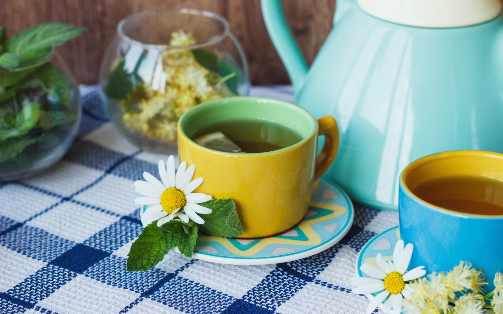 Чай с цветами ромашки в желтой чашке на столе