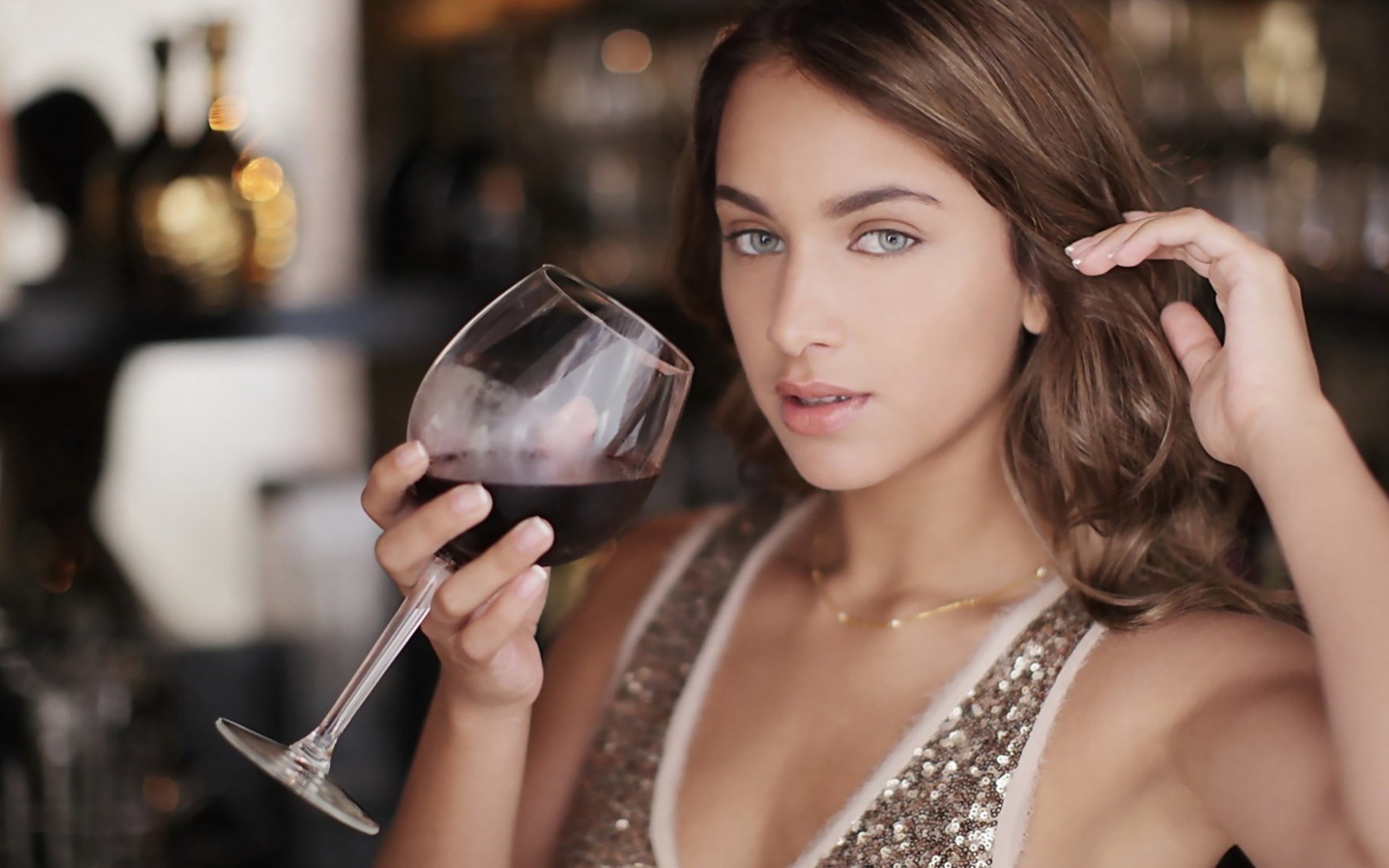 Красивая голубоглазая девушка с бокалом красного вина в руке