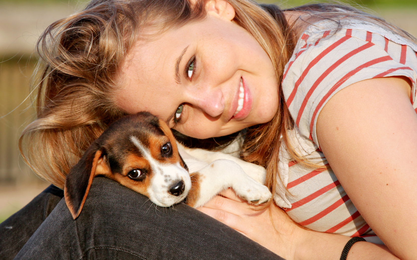 Убающаяся девушка шатенка с милым щенком на руках