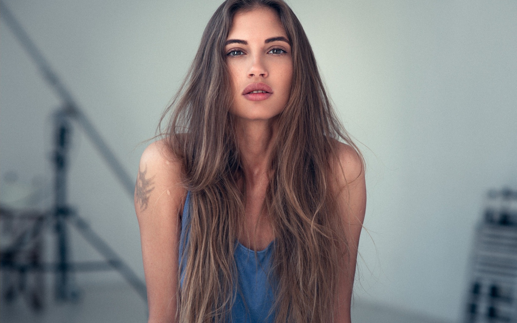 Девушка с длинными волосами и татуировкой на плече 