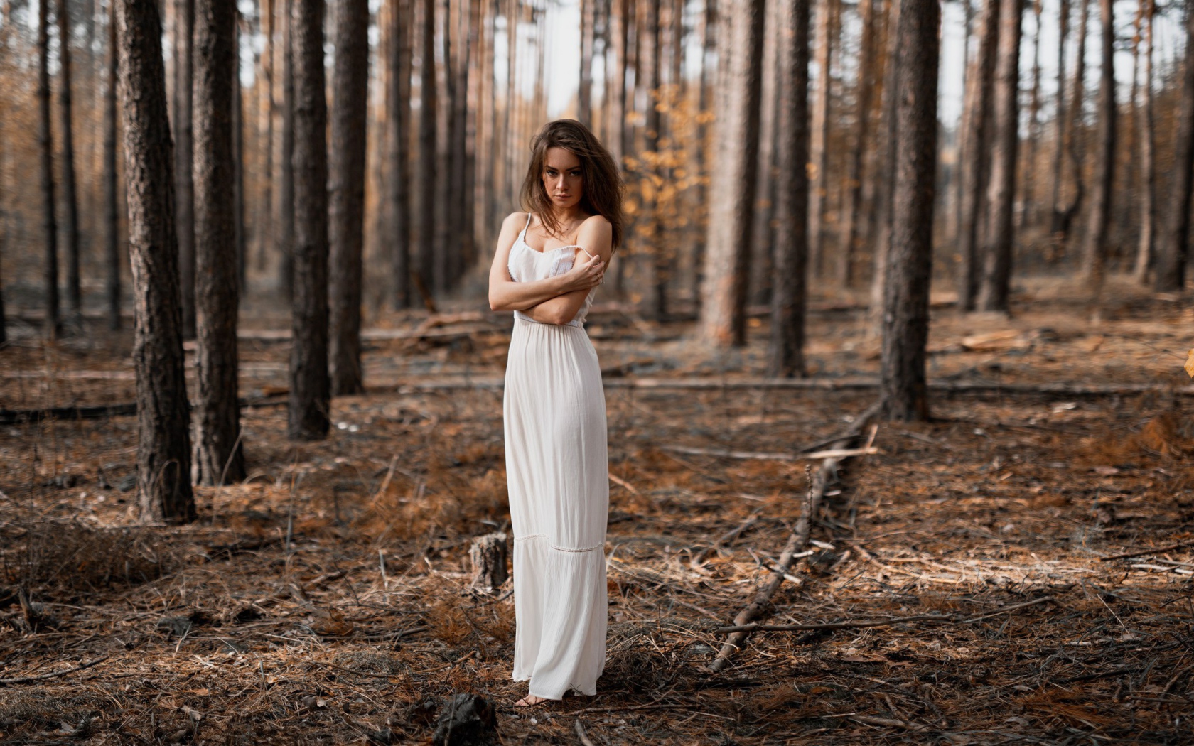 Молодая девушка в белом платье в лесу 