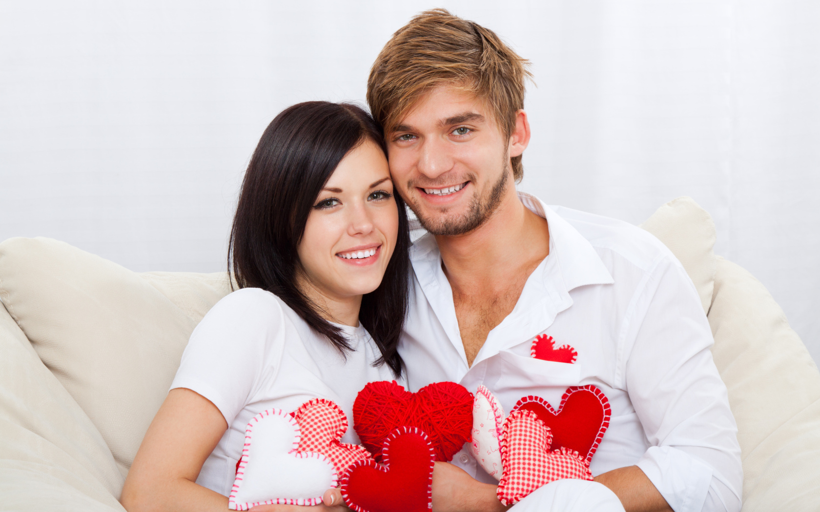 Красивая влюбленная пара с маленькими сердечками в руках