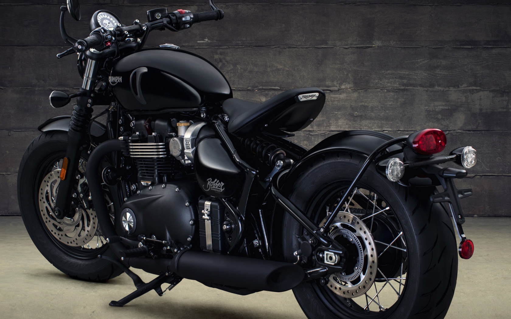 Черный мотоцикл Triumph Bonneville Bobber, 2018 вид сзади