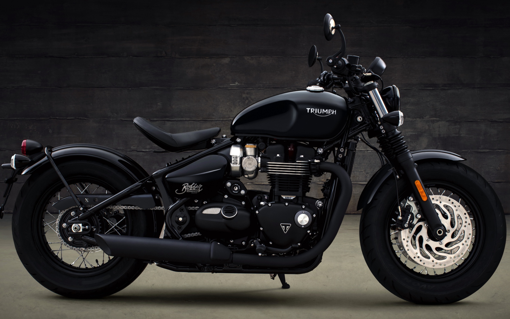 Черный мотоцикл Triumph Bonneville Bobber, 2018 вид сбоку