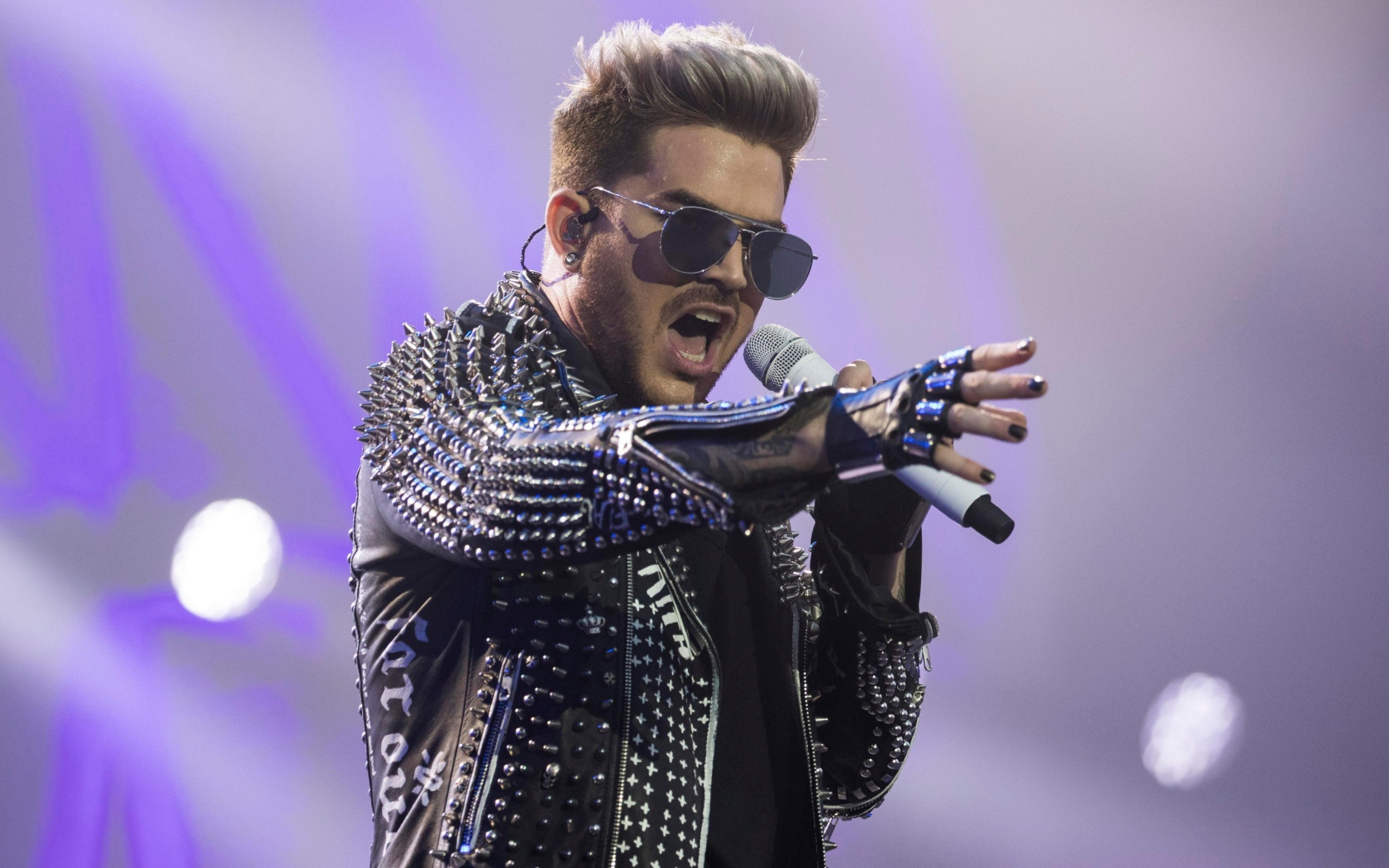 Американский певец Адам Ламберт на сцене с микрофоном