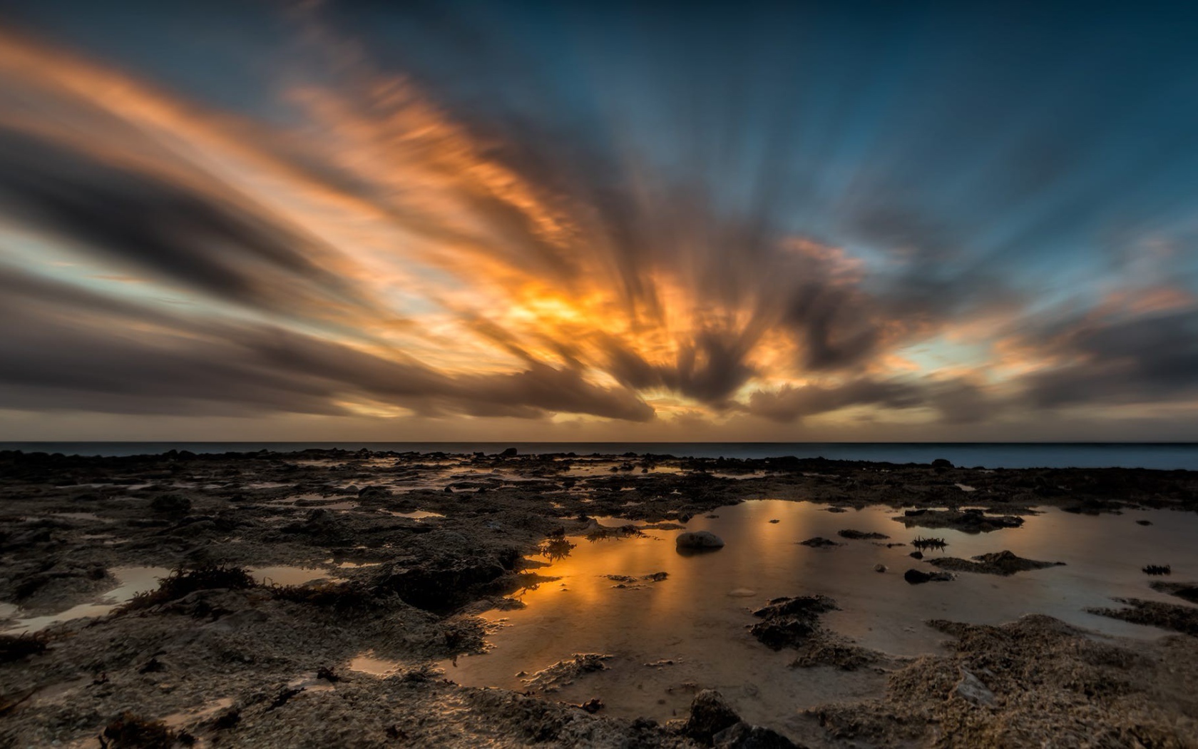 Закат солнца в облаках над водой 