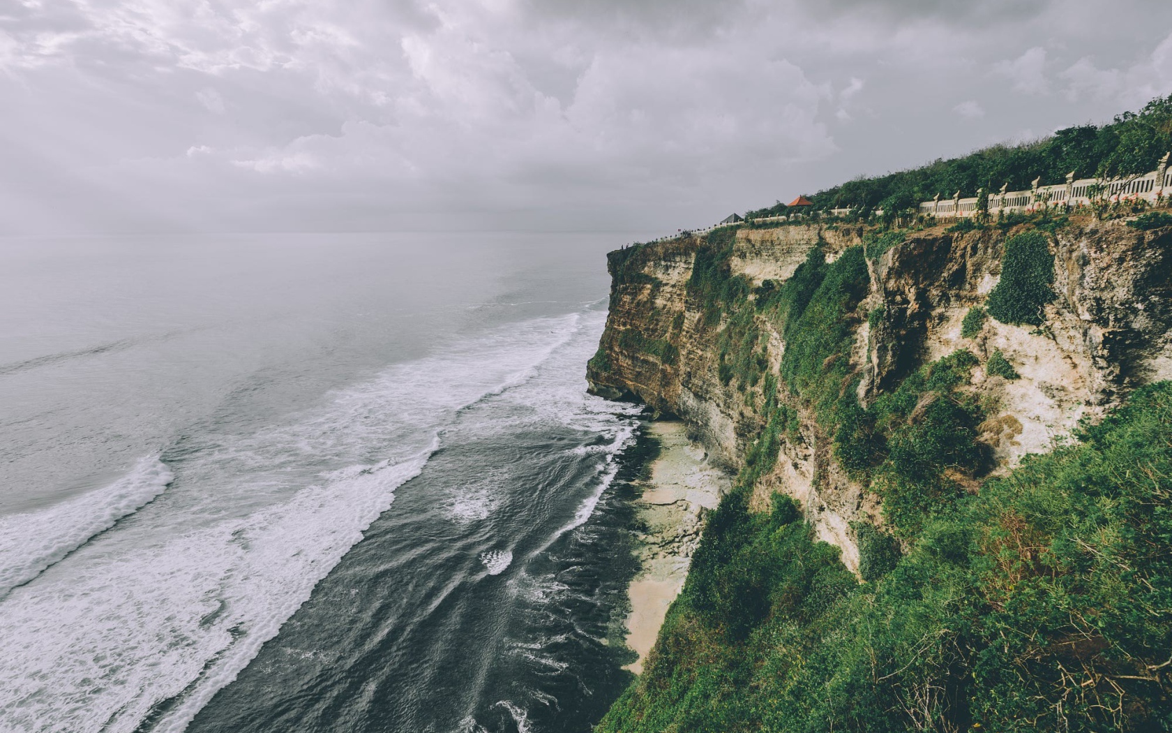 Бушующие волны у зеленого утеса 