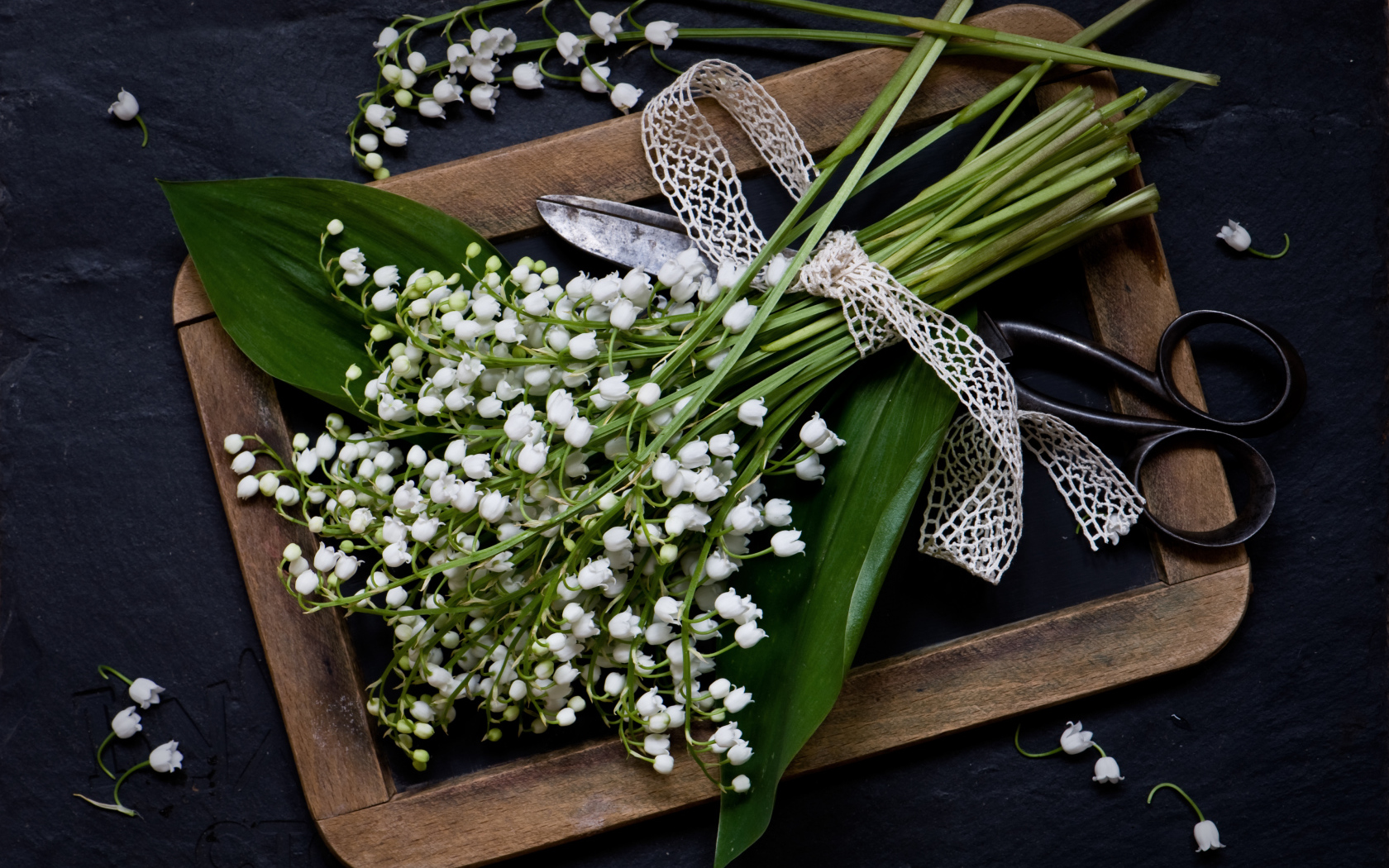 Букет белых ландышей с ножницами на столе