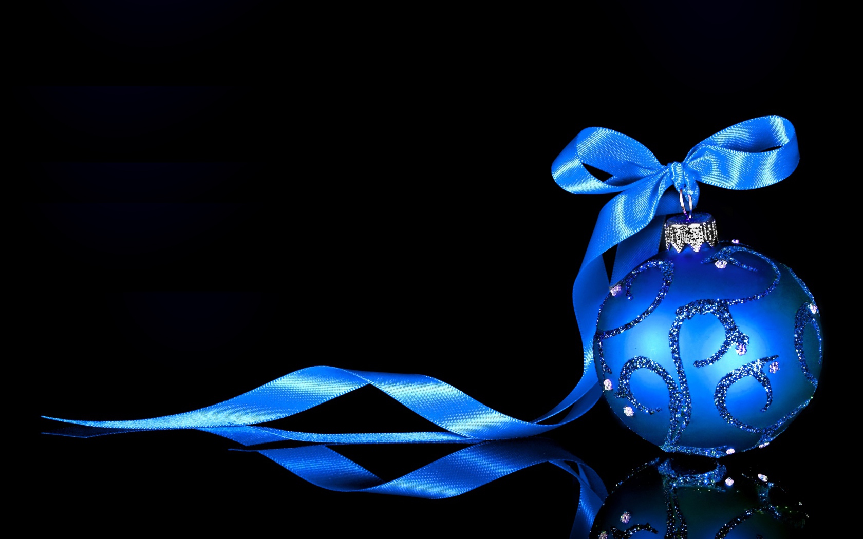 Красивый елочный шар с голубой лентой на черном фоне