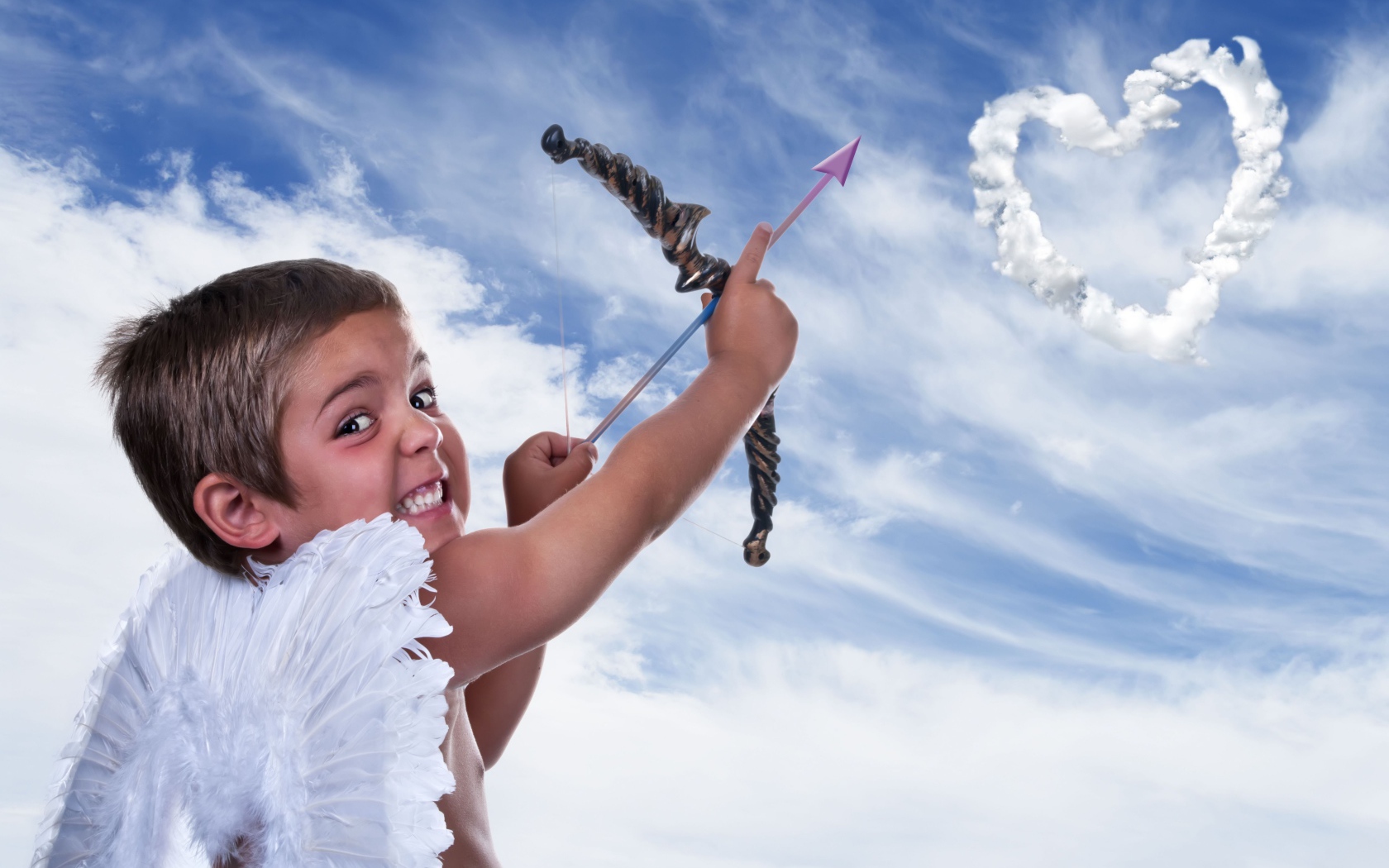 Мальчик в костюме купидона пускает стрелу в небо