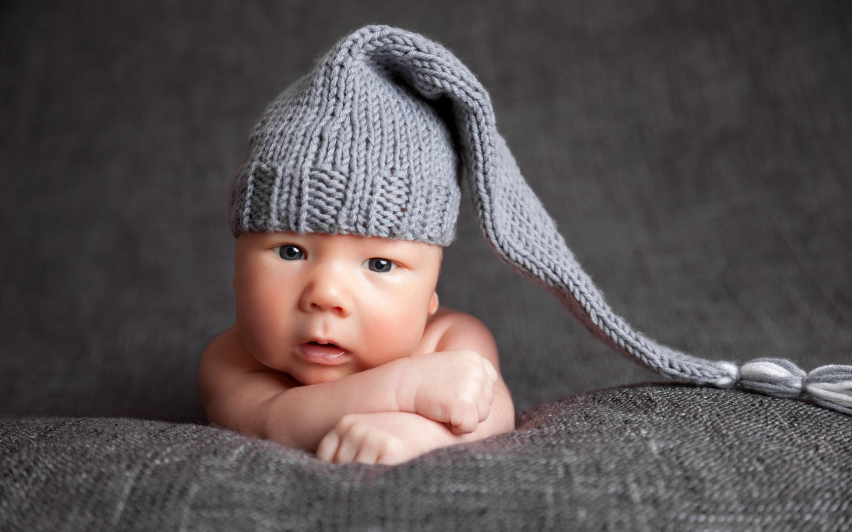 Милый младенец в большой серой вязаной шапке