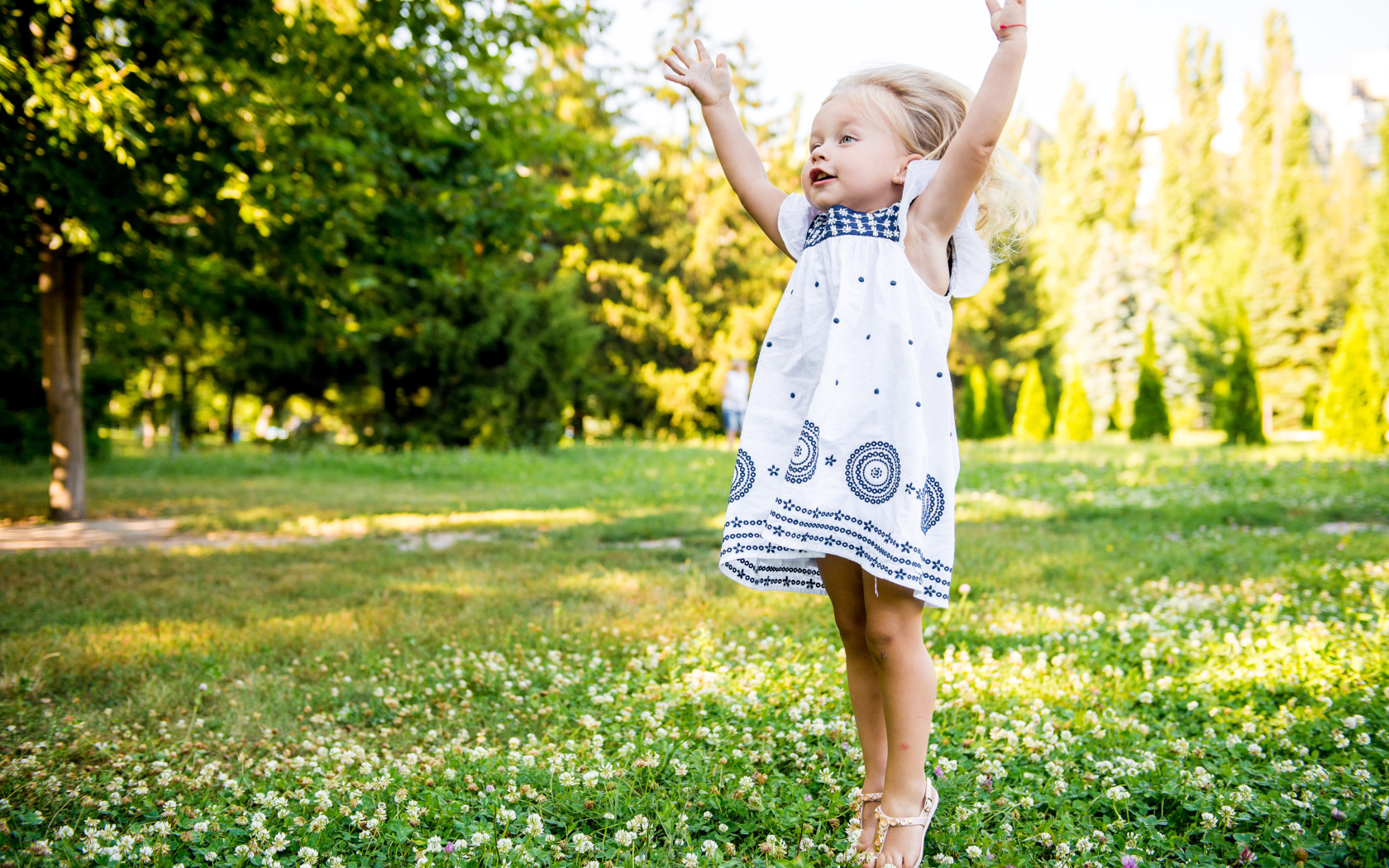 Девочка в красивом платье гуляет на зеленом лугу