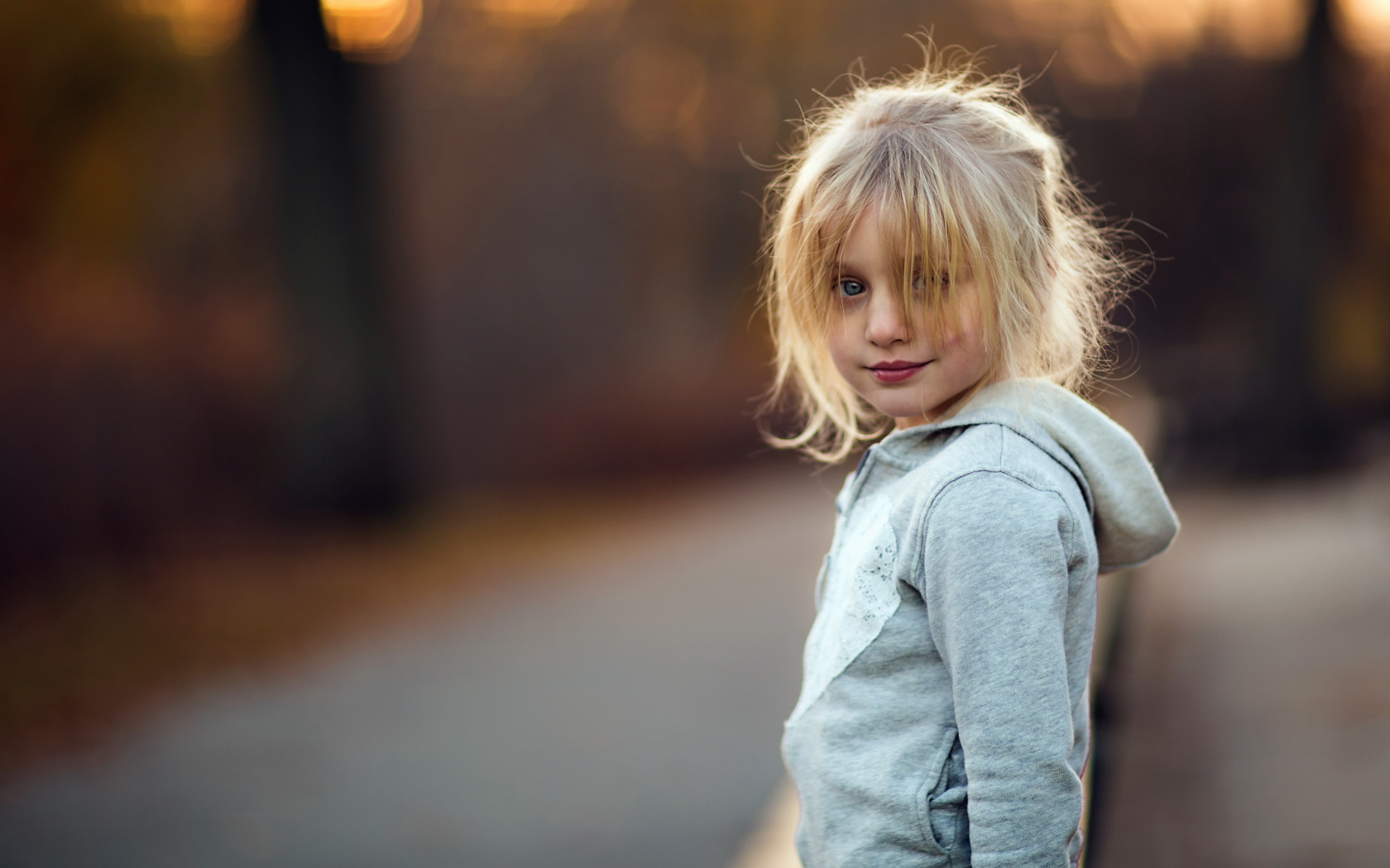Маленькая девочка блондинка в серой кофте