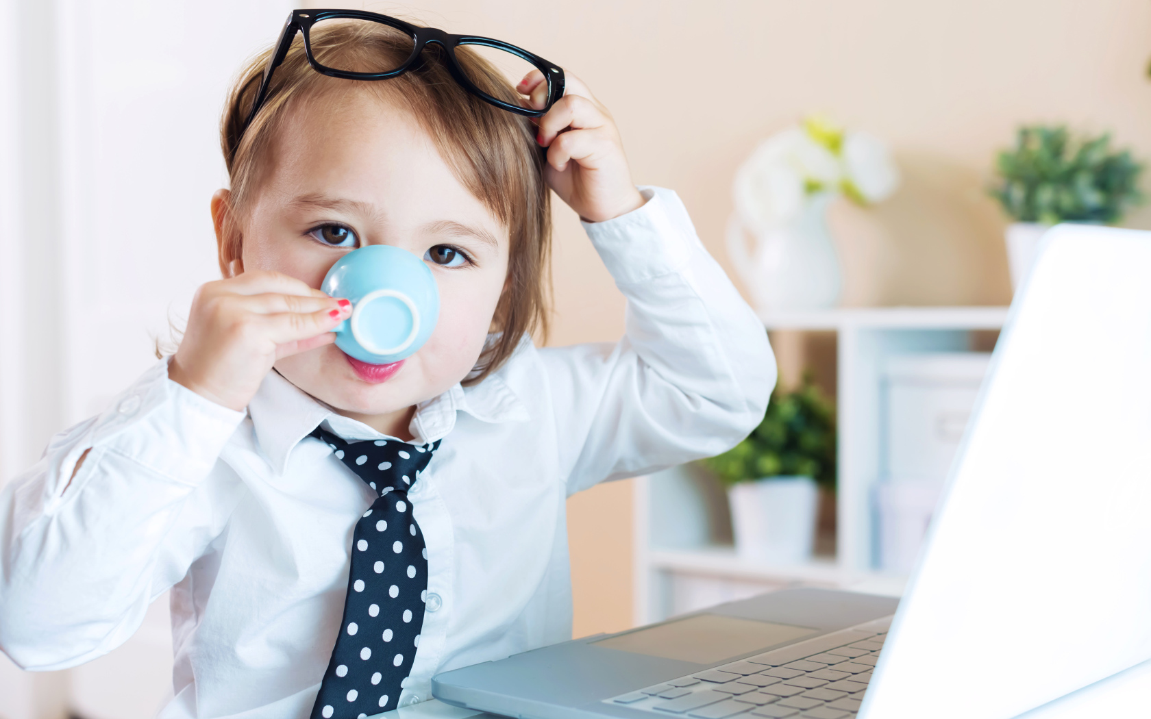 Маленький мальчик в деловом костюме и с чашкой