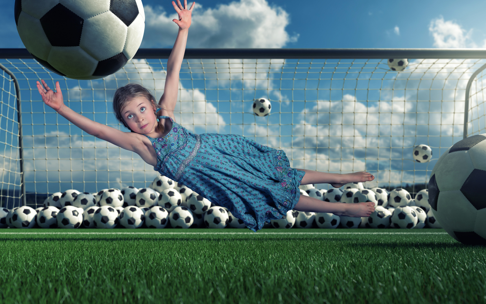 Маленькая девочка вратарь ловит мяч в воротах