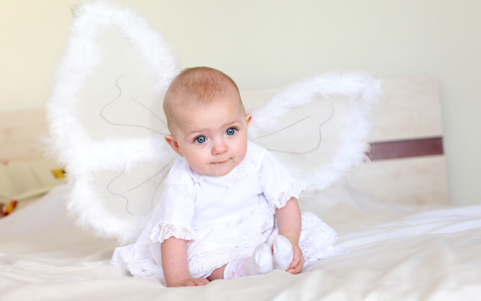 Маленькая девочка в красивом белом платье с крыльями