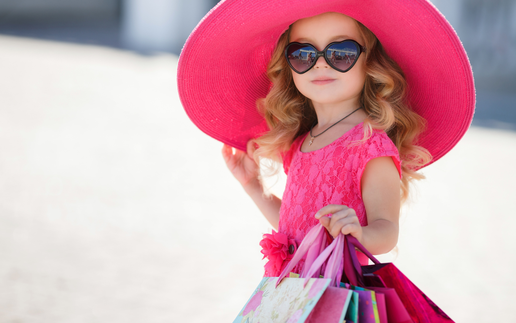 Маленькая девочка модница в большой розовой шляпе