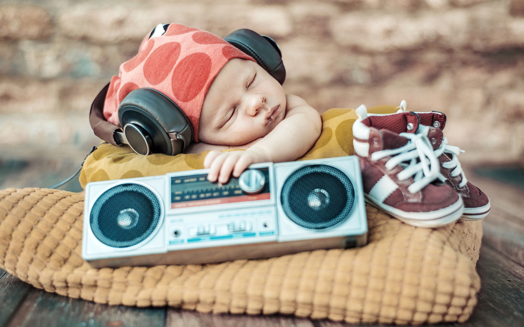 Спящий младенец в наушниках и с игрушечным магнитофоном