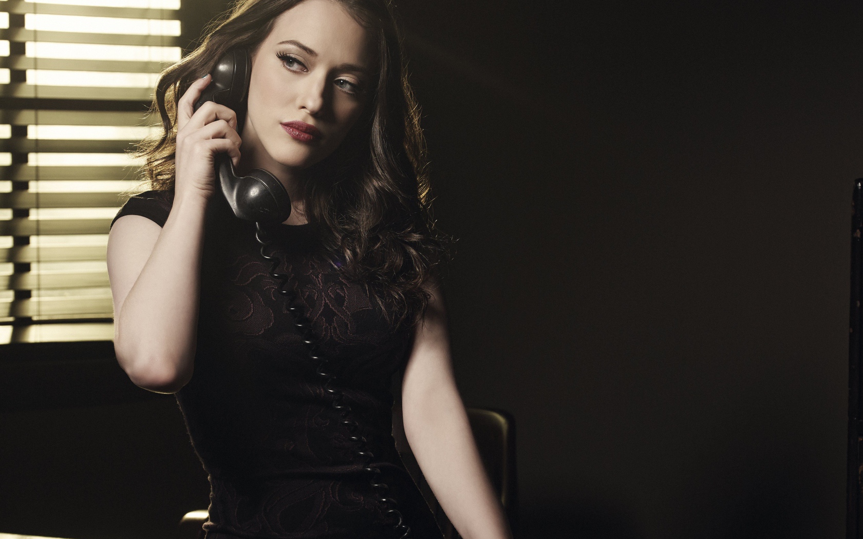 Актриса Кэт Деннингс в черном платье с телефоном в руках