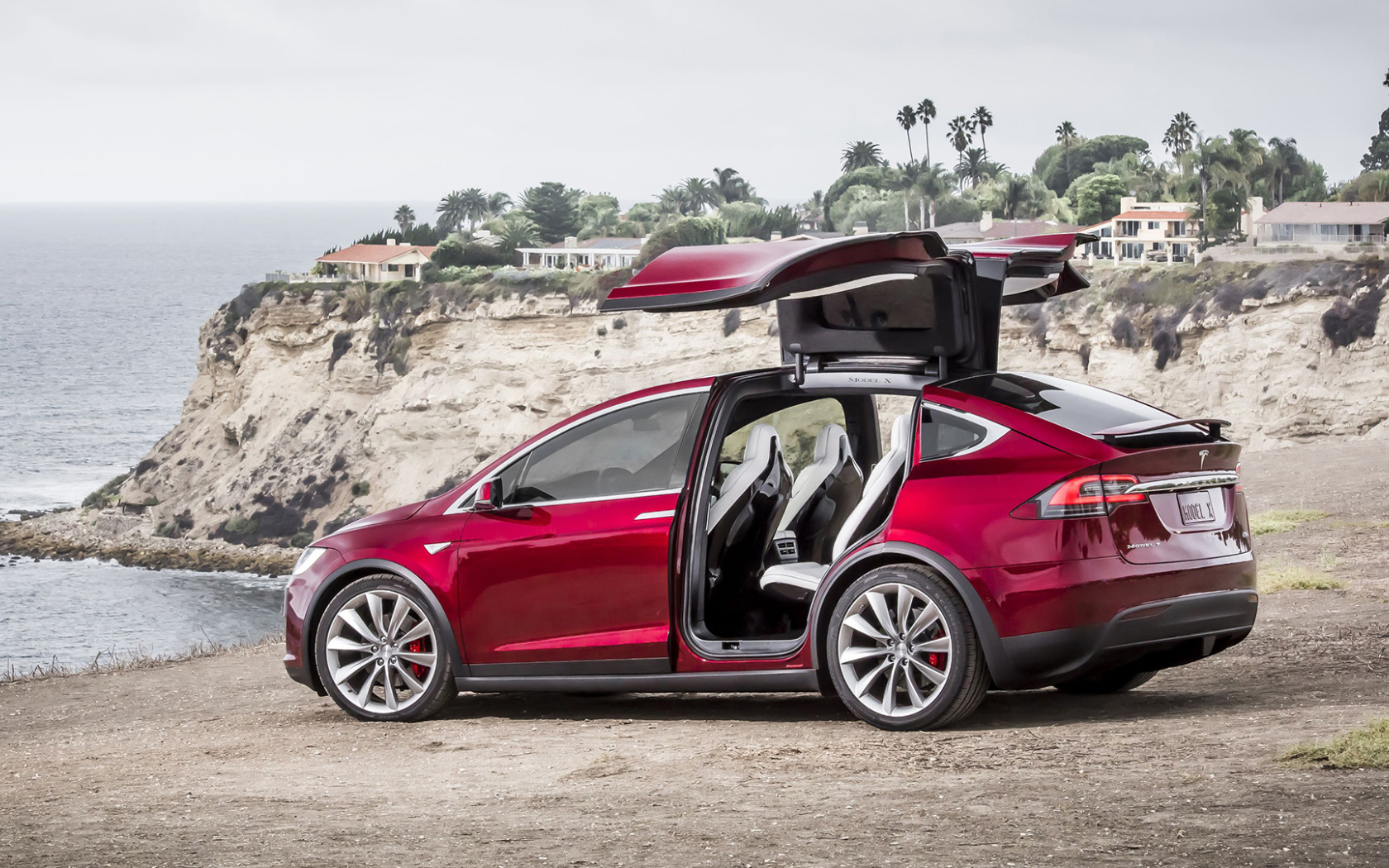 Красный электромобиль Тесла на берегу 