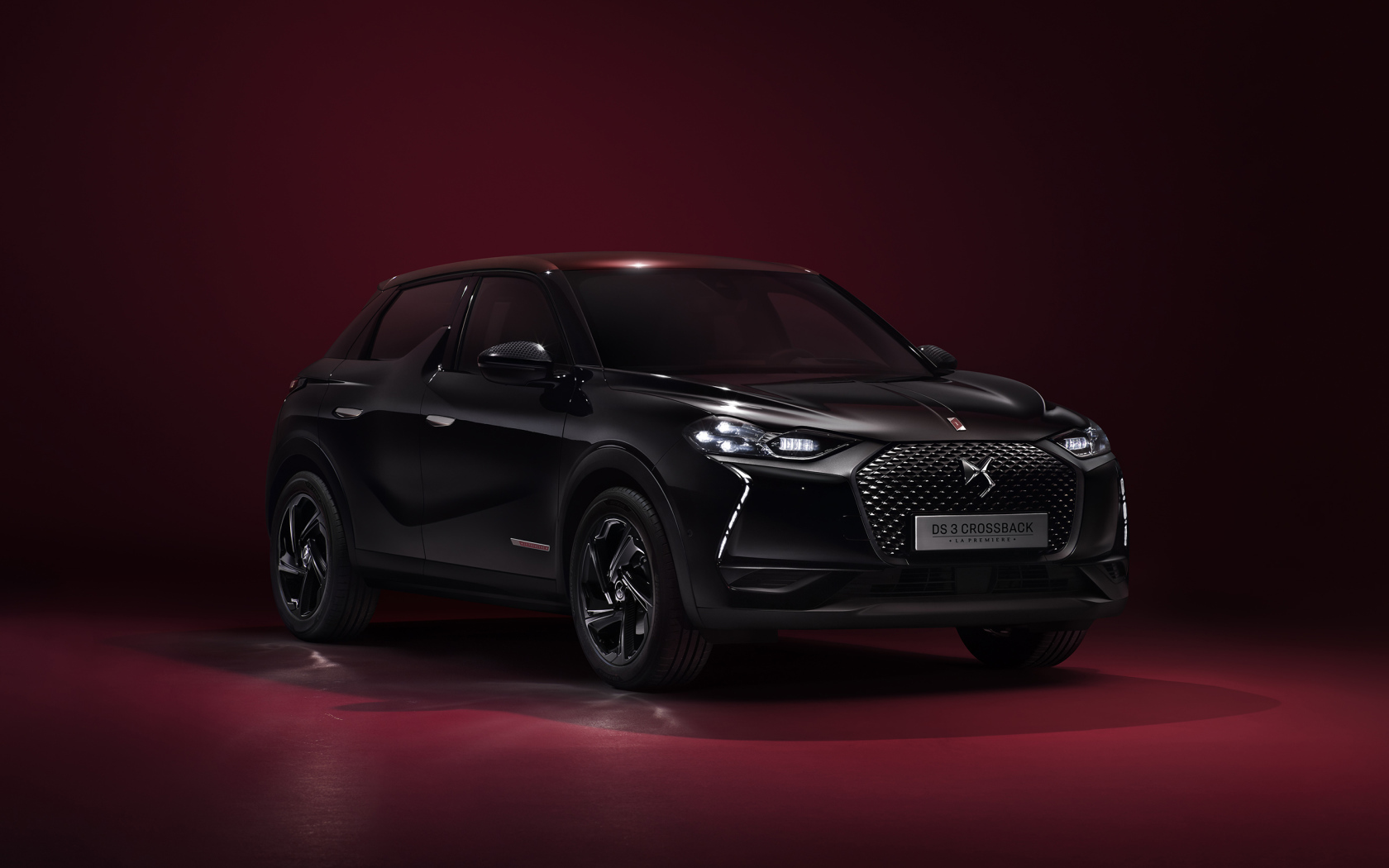 Черный стильный автомобиль DS 3  2019 года на бордовом фоне