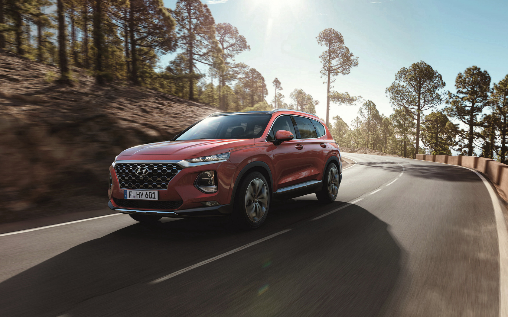 Красный автомобиль Hyundai Santa Fe, 2018 года на трассе