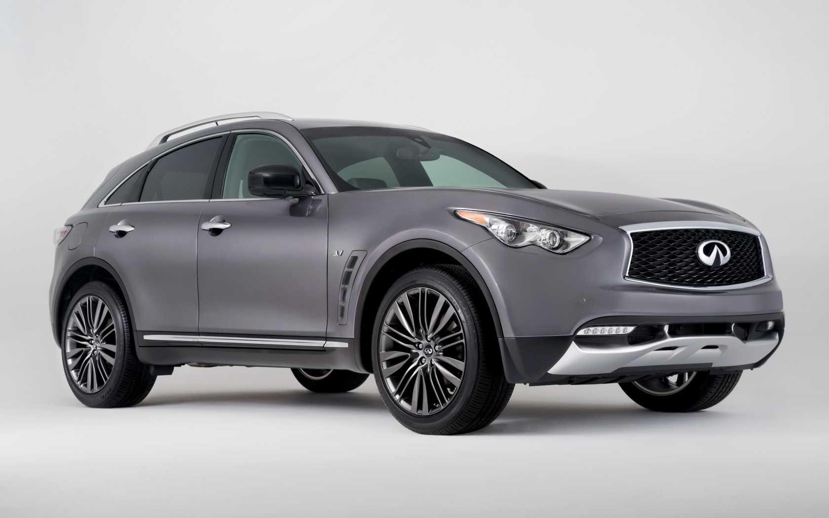 Серебристый автомобиль Infiniti QX70 на сером фоне