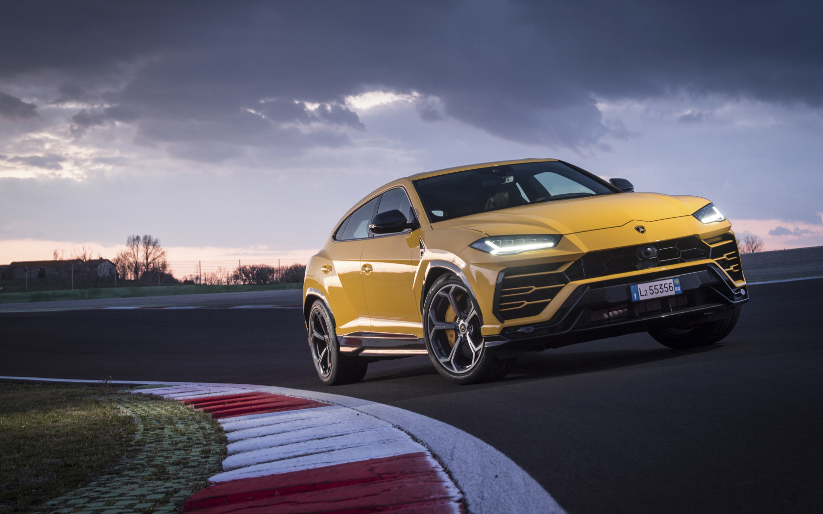 Желтый внедорожник Lamborghini Urus  едет по дороге