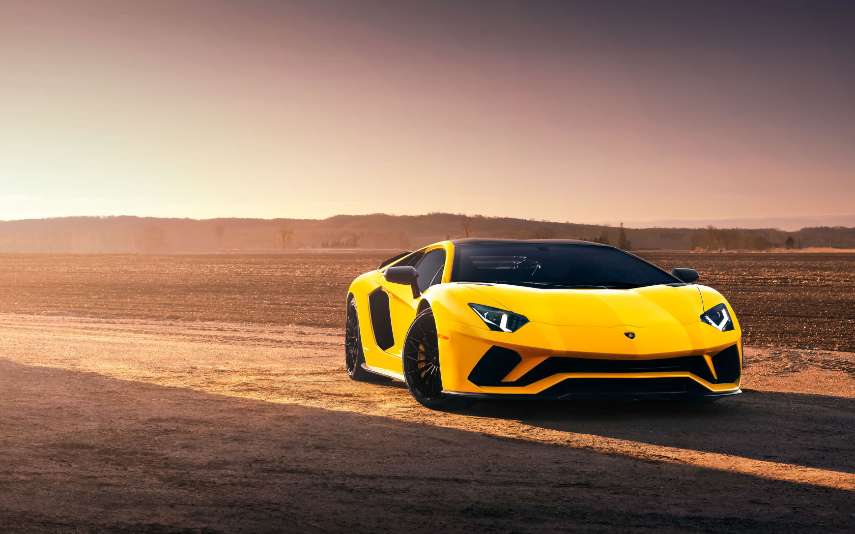 Желтый спортивный автомобиль Lamborghini Aventador S в лучах солнца